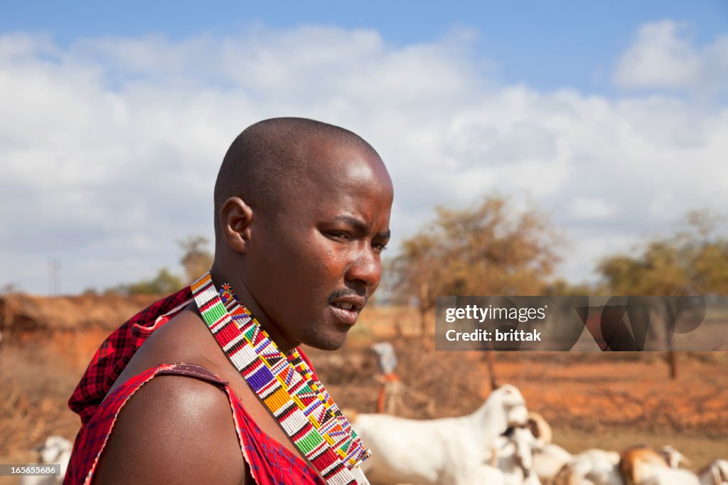 Young maasaj with traditional jevellry. Goats in the background.