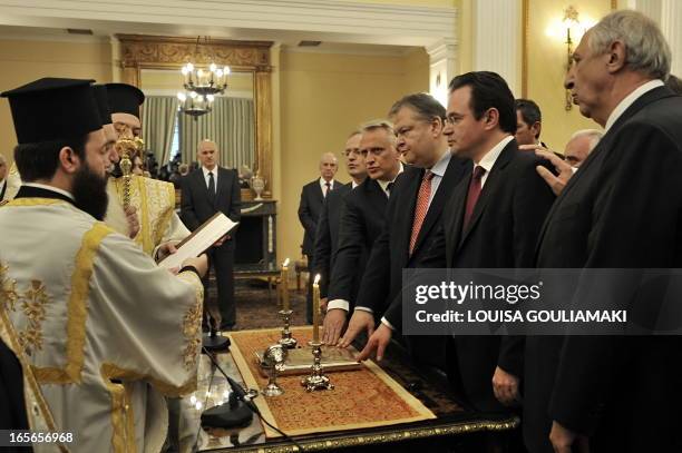 Newly appointed Greek ministers and deputy ministers are sworn in in front of Orthodox priests at the Presidential palace in Athens on June 17, 2011....