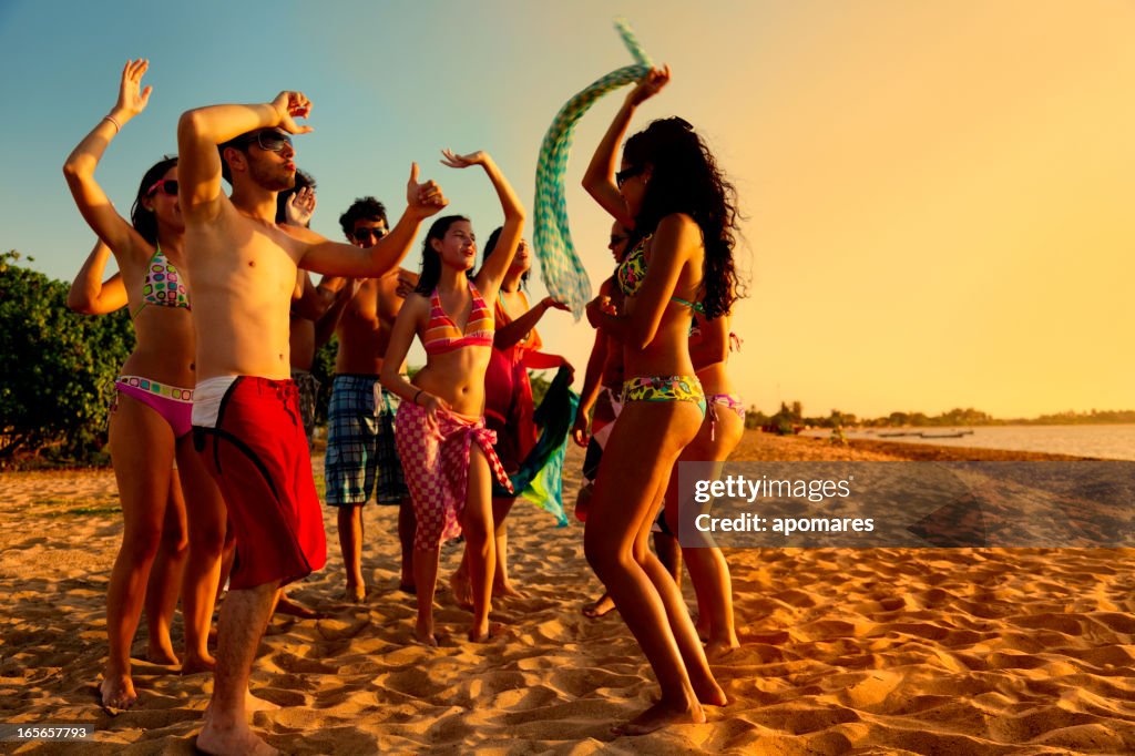 Groupe de jeunes gens à une chaude soirée d'été à la plage