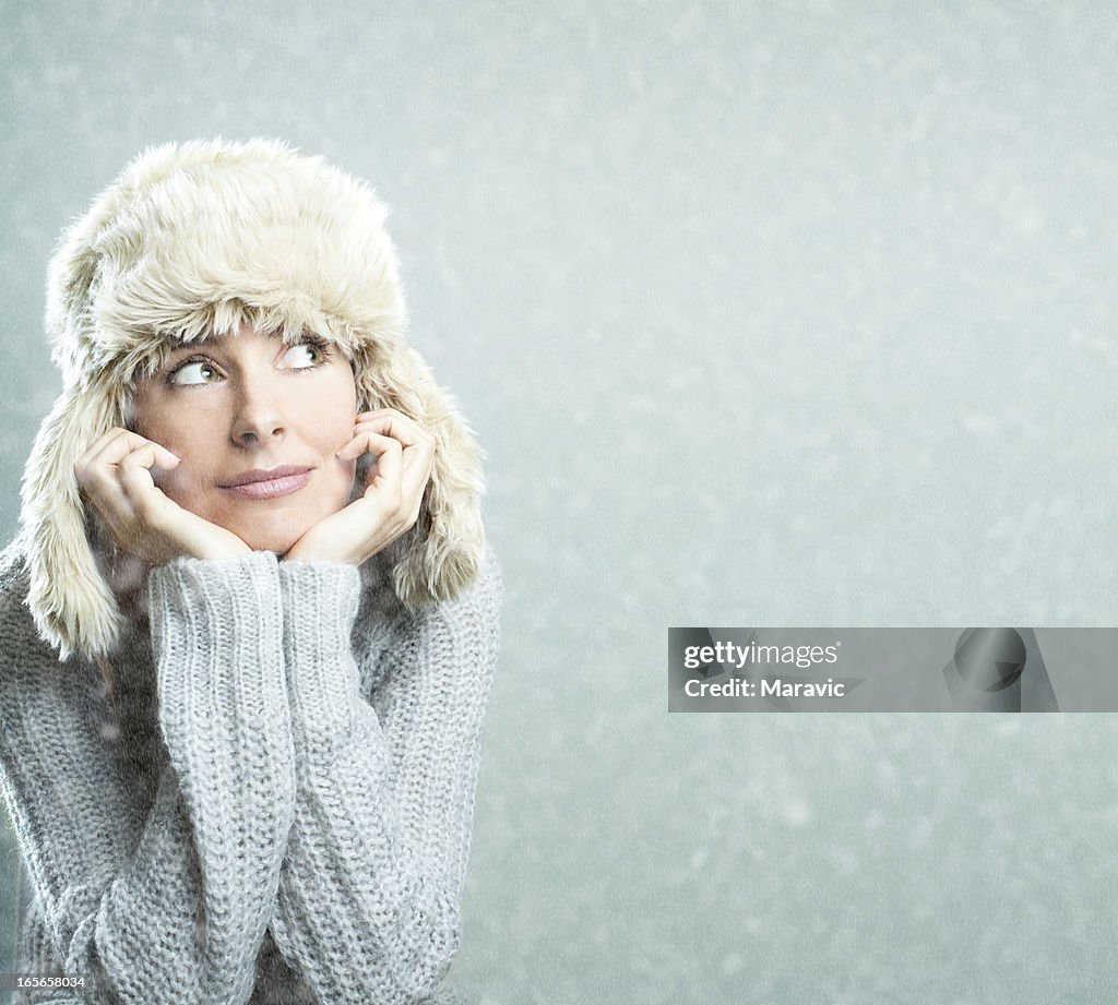 A woman leaning on her hands while wearing a hat