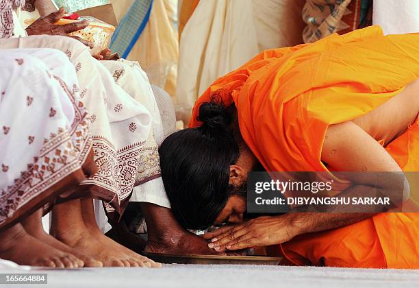 Indian Yoga Guru, Baba Ramdev seek blessing from elderly tribal women after washing their feet during a function in Kolkata on April 5, 2013. Ramdev...