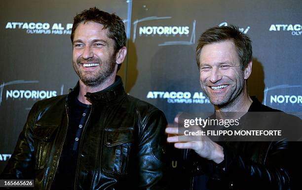 Scottish actor Gerard Butler and US actor Aaron Eckhart pose during a photocall for the movie "Olympus has fallen" in downtown Rome on April 5, 2013....