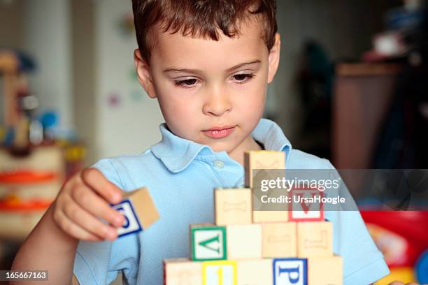 garçon autistes bâtiment avec blocs - preschool age photos et images de collection