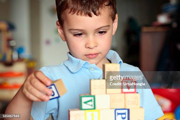 autistic boy building with blocks - alternative therapy stock pictures, royalty-free photos & images