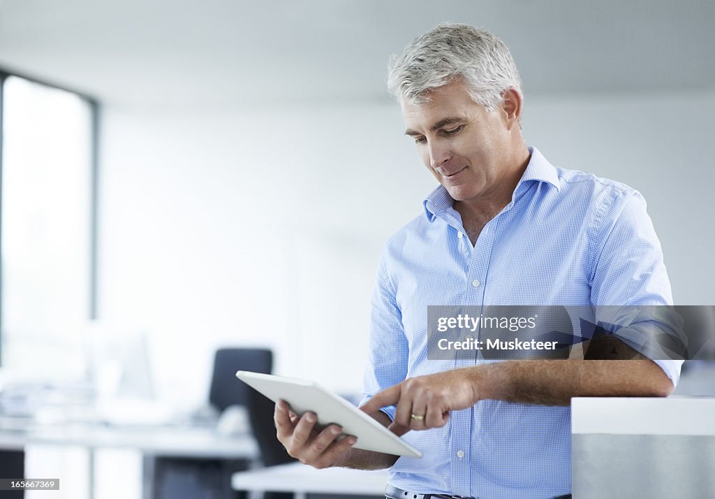 Businessman surfing the internet on his tablet