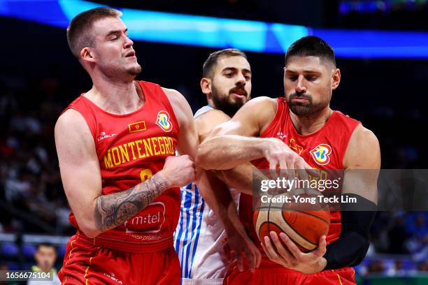 Emmanouil Chatzidakis of Greece competes for a rebound against Dino Radoncic and Nikola Vucevic of Montenegro in the third quarter during the FIBA...