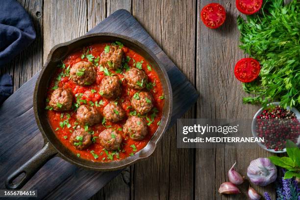 meat balls with tomato sauce homemade in rustic cast iron pan over wood - meatball imagens e fotografias de stock