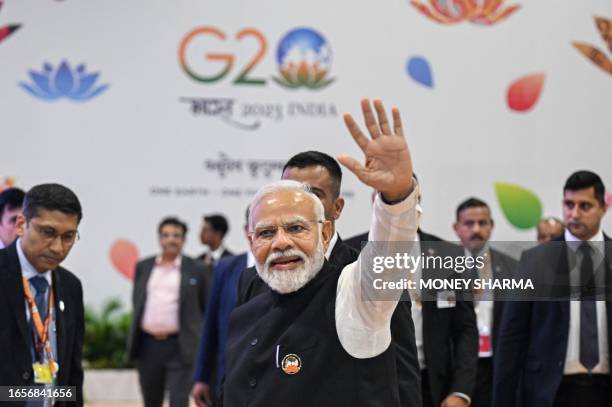 India's Prime Minister Narendra Modi waves to the media representatives during his visit to the International media centre, at the G20 summit venue,...