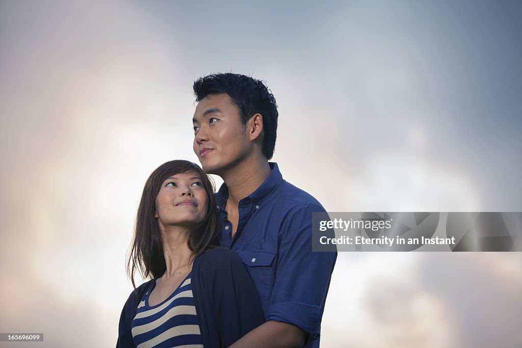 Couple hugging outdoors at sunset