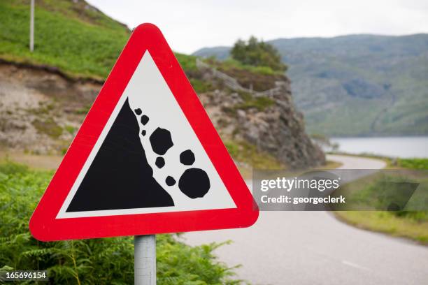 falling rocks warning road sign - steep road stock pictures, royalty-free photos & images