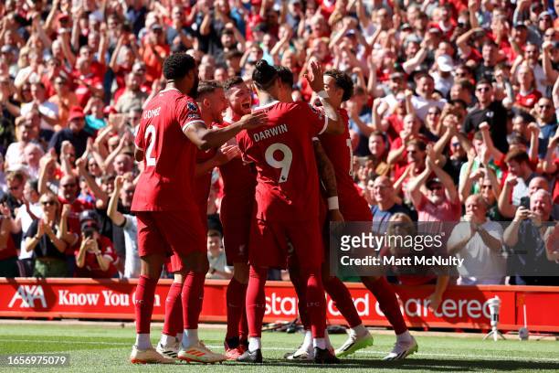 Dominik Szoboszlai of Liverpool celebrates with teammates after scoring the team's first goal during the Premier League match between Liverpool FC...