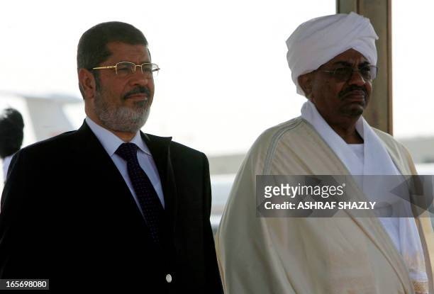 Sudanese President Omar al-Bashir and Egyptian counterpart Mohamed Morsi listen to their national anthems during a departure ceremony at Khartoum...
