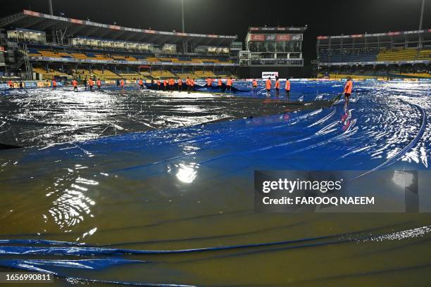 Ground staff cover the pitch after rain stopped play during the Asia Cup 2023 super four one-day international cricket match between India and...