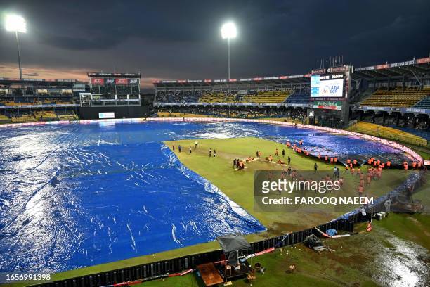 Ground staff cover the pitch after rain stopped play during the Asia Cup 2023 super four one-day international cricket match between India and...