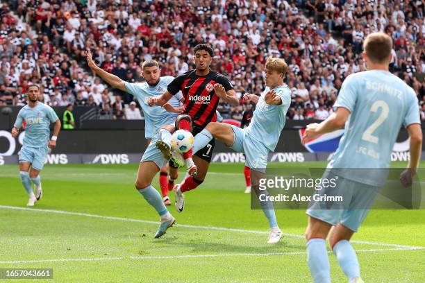 Omar Marmoush of Eintracht Frankfurt battles for possession with Julian Chabot and Timo Hubers of 1.FC Köln during the Bundesliga match between...