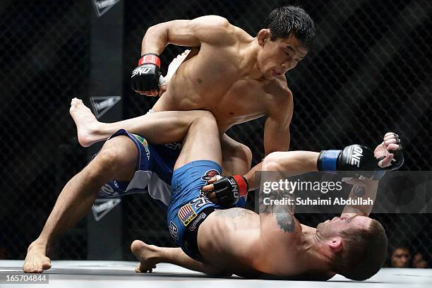 Masakatsu Ueda of Japan grounds and pounds Jens Pulver of United States of America during the One Fighting Championship at Singapore Indoor Stadium...