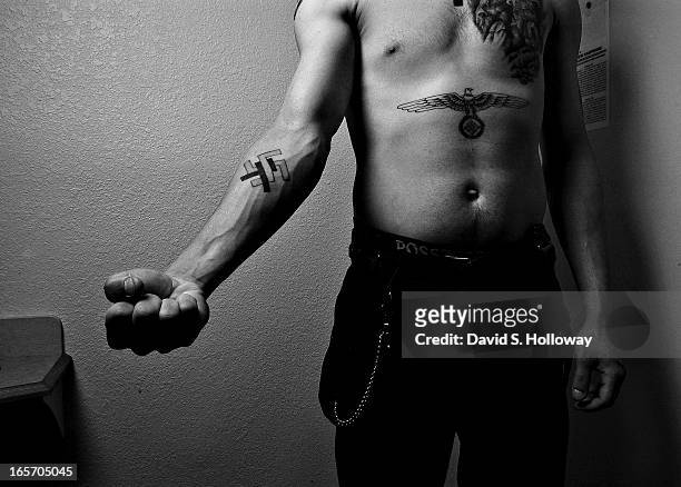 Ken Zrallack, leader of the skinhead gang The Connecticut White Wolves shows off his tattoos in a motel room on May 8, 2005 near Salem, New...