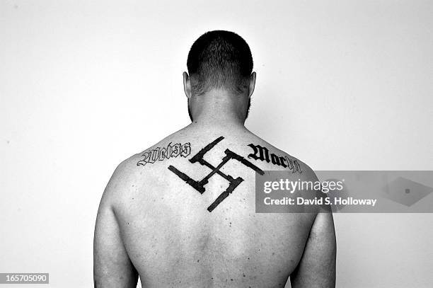 Sam Shoen displays his unfinished white supremacist tattoos at a friend's home on November 20, 2004 in Wabasha, Minnesota.