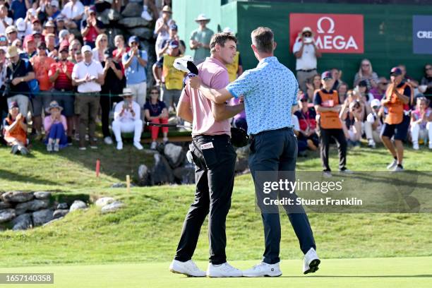 Ludvig Aberg of Sweden shake hands with Alexander Bjork of Sweden after finishing their round on the 18th hole during Day Four of the Omega European...