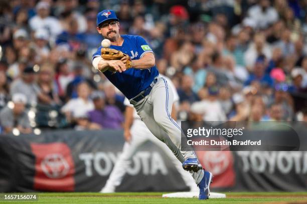 Davis Schneider of the Toronto Blue Jays throws to first base after fielding a soft ground ball against the Colorado Rockies in the third inning at...