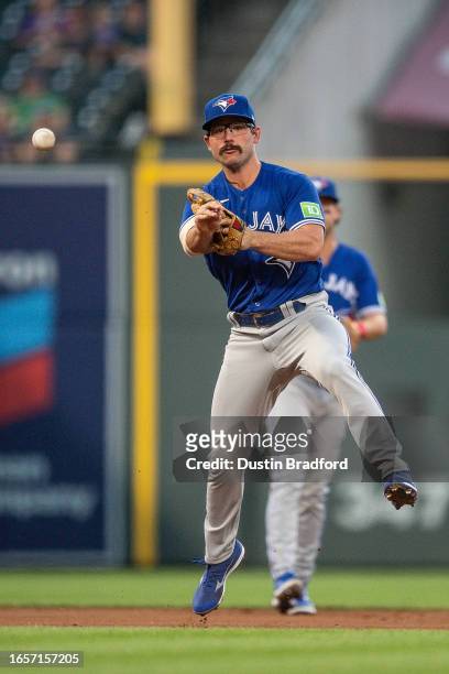 Davis Schneider of the Toronto Blue Jays throwes to first base after fielding a ground ball in the second inning against the Colorado Rockies at...