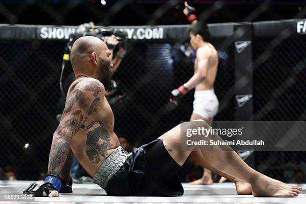 Kotetsu Boku of Japan sits as Shinya Aoki of Japan does a victory lap after his Lightweight World Championship bout win during the One Fighting...