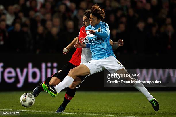 Darryl Janmaat of Feyenoord is tackled by Yuki Otsu of Venlo during the Eredivisie match between Feyenoord and VVV Venlo at De Kuip on April 5, 2013...