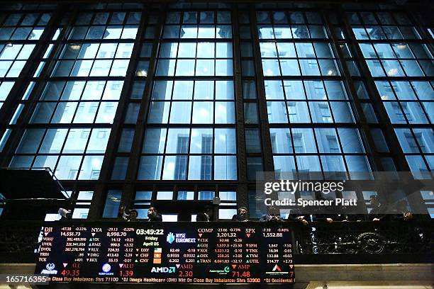 Visitors look out at the floor of the New York stock Exchange at the end of the trading day on April 5, 2013 in New York City. Following news of a...