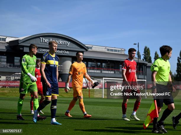 Goalkeeper Fabian Mrozek and captain Tom Hill of Liverpool walk out at the start of the PL2 game at AXA Training Centre on September 03, 2023 in...