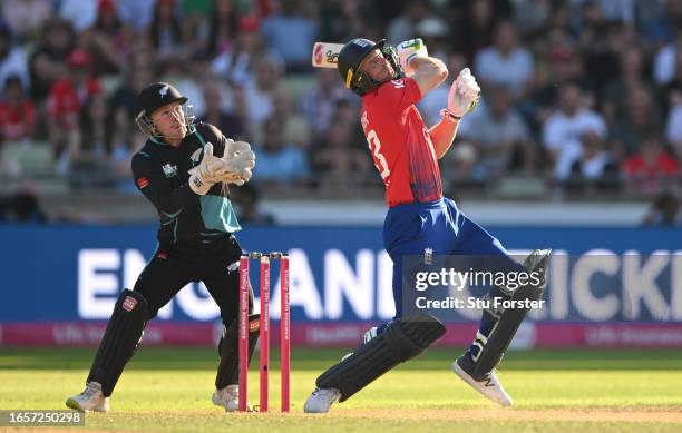 New Zealand wicketkeeper Tim Seifert looks on as England batsman Jos Buttler hits out only to be caught by Mitchell Santner off his own bowling...