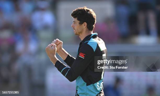 New Zealand bowler Mitchell Santner celebrates after taking the wicket of Jos Buttler off his own bowling during the 3rd Vitality T20I between...