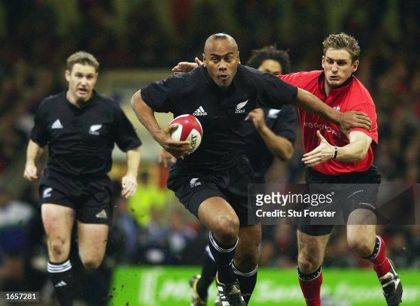 Jonah Lomu of New Zealand breaks a tackle by Jamie Robinson of Wales during the Rugby Union International match between Wales and New Zealand at the...