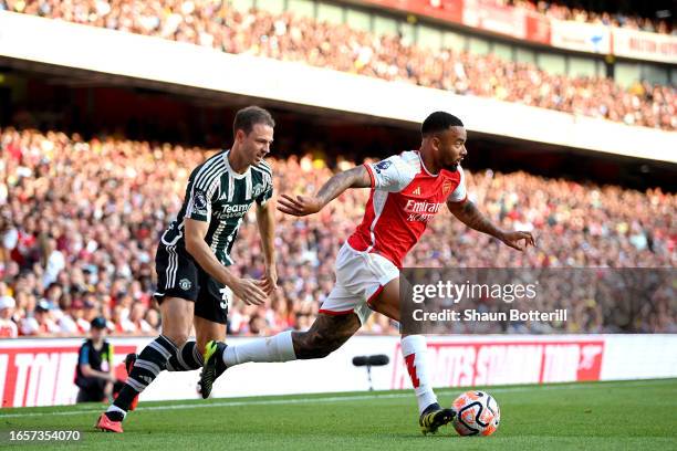 Gabriel Jesus of Arsenal battles for possession with Jonny Evans of Manchester United during the Premier League match between Arsenal FC and...