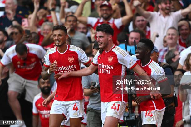 Declan Rice of Arsenal celebrates with Ben White and Eddie Nketiah after scoring the team's second goal during the Premier League match between...