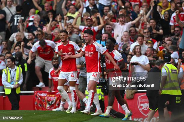 Declan Rice of Arsenal celebrates with Ben White and Eddie Nketiah after scoring the team's second goal during the Premier League match between...