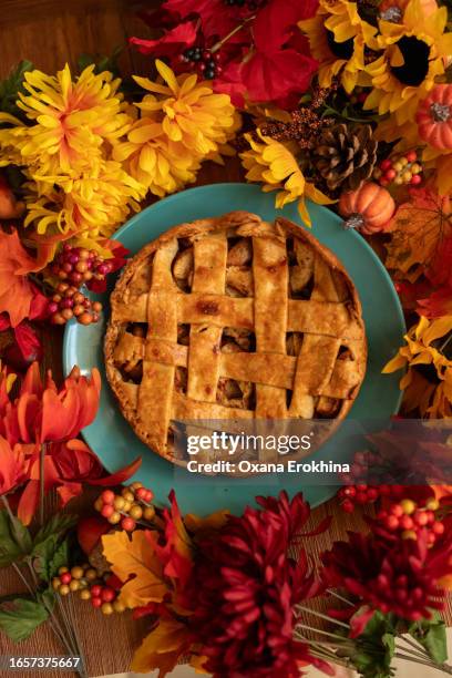 autumn pretty apple pie surrounded by colorful leaves on a wooden table - apple pie stock pictures, royalty-free photos & images