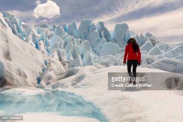 woman with red jacket in front of perito moreno glacier, el calafate, santa cruz province, argentina. - moraine stock pictures, royalty-free photos & images