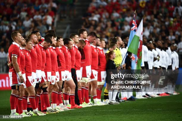 Wales' team players line up for the national anthems before the France 2023 Rugby World Cup Pool C match between Wales and Fiji at Stade de Bordeaux...