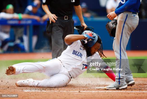 Vladimir Guerrero Jr. #27 of the Toronto Blue Jays scores a run on a wild pitch by Cole Raglan's of the Kansas City Royals in the sixth inning at...