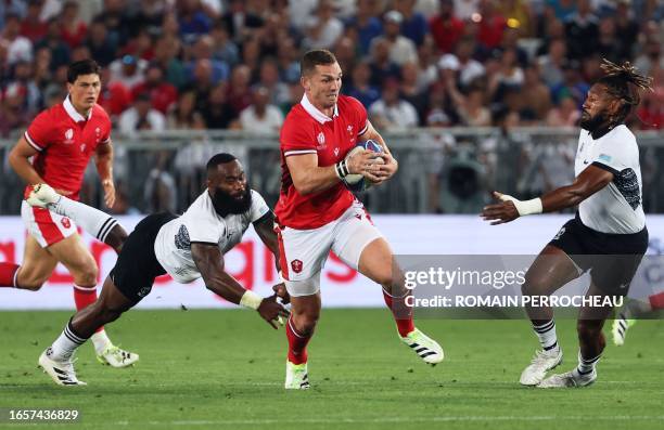 Wales' outside centre George North runs to evade Fiji's inside centre Semi Radradra during the France 2023 Rugby World Cup Pool C match between Wales...