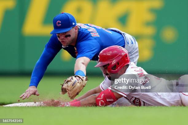 Christian Encarnacion-Strand of the Cincinnati Reds slides into second base for a double past Nico Hoerner of the Chicago Cubs in the sixth inning at...