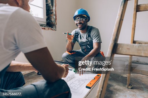 Two Construction Workers Working Together on an Apartment Renovation Two Construction Workers Working Together on an Apartment Renovation