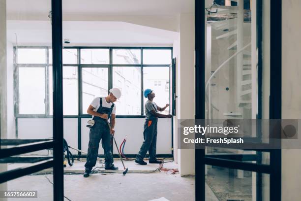 アパートのリフォームで一緒に働く2人の建設作業員 - 工業団地 ストックフォトと画像