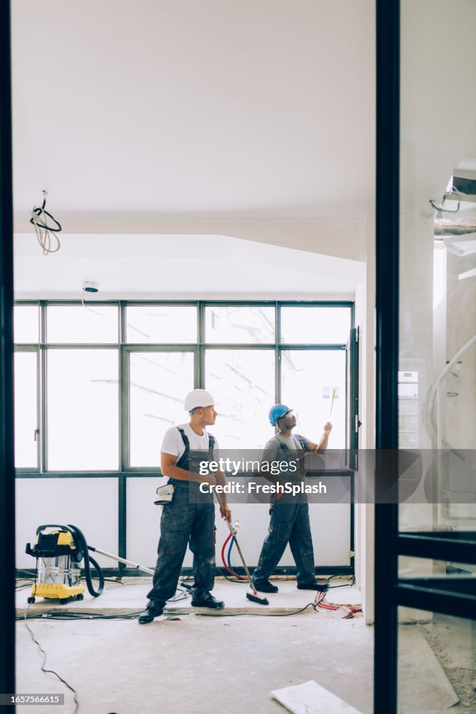 Two Construction Works Two Construction Workers Working Together On An Apartment Renovation ...