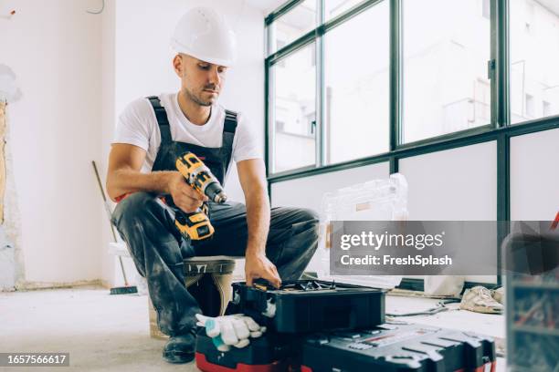caucasian construction worker renovating an apartment - gereedschap stockfoto's en -beelden