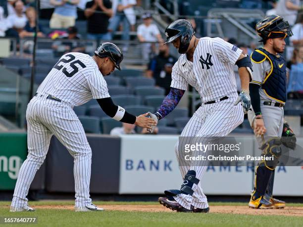 Giancarlo Stanton of the New York Yankees is congratulated by Gleyber Torres after hitting a game-tying two-run home run in the bottom of the twelfth...
