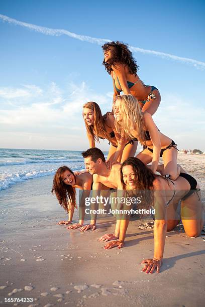 gruppo di amici avendo divertimento sulla spiaggia - human pyramid foto e immagini stock