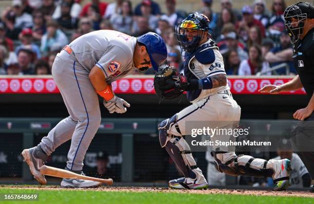 Francisco Alvarez of the New York Mets grabs his wrist after being hit by a pitch in the fifth inning of the game against the Minnesota Twins at...