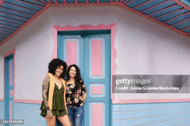 two young latin women smile looking at camera - colombia street stock pictures, royalty-free photos & images