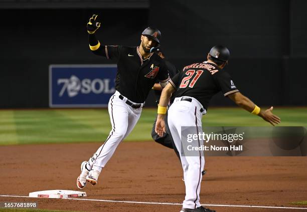 Lourdes Gurriel Jr of the Arizona Diamondbacks celebrates with third base coach Tony Perezchica after hitting a solo home run against the Baltimore...